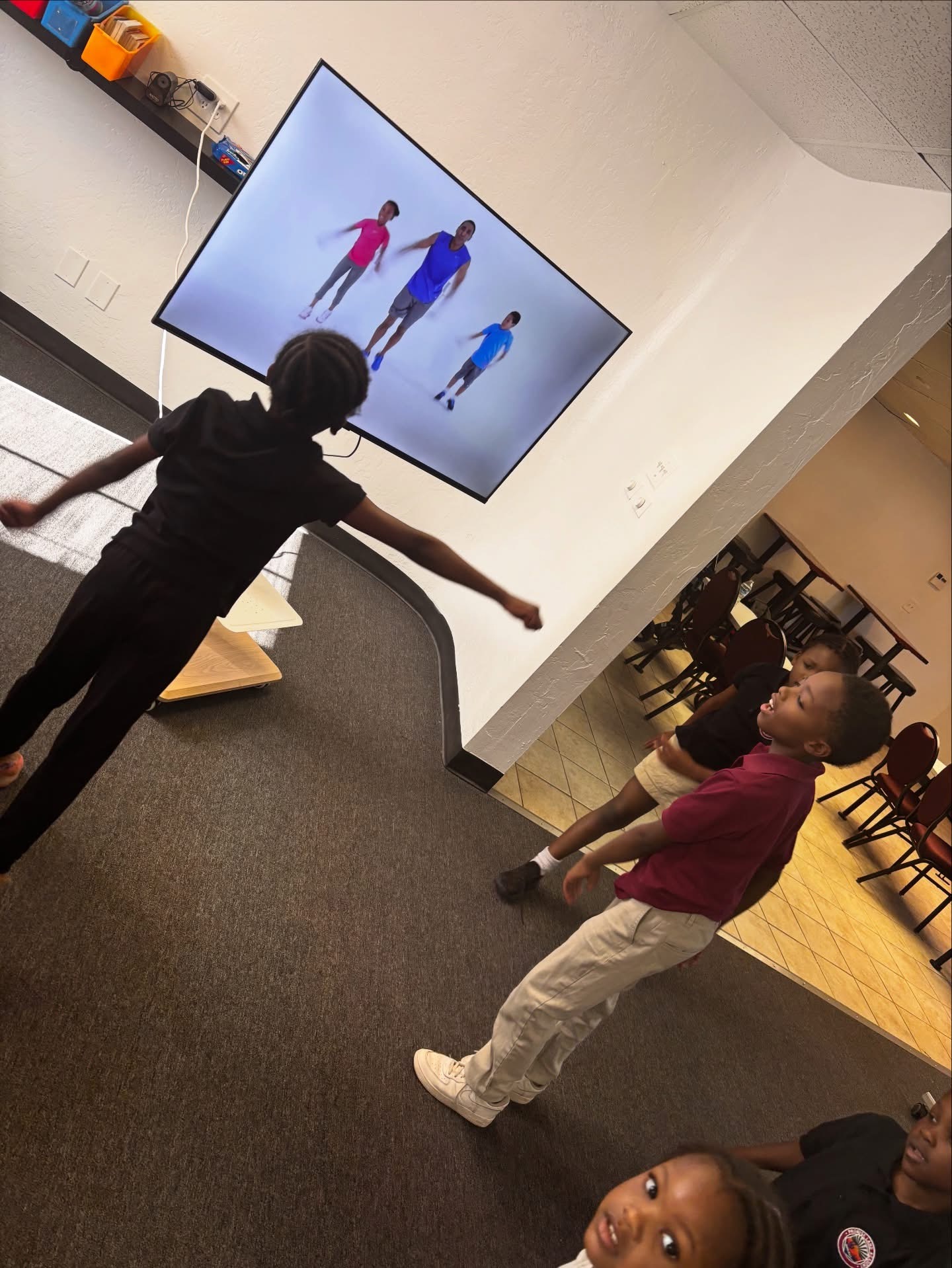 Students following a movement and fitness video together